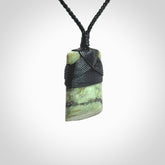 Hand carved from a lovely piece of local New Zealand Jade. The quality of the workmanship and design is outstanding - this is a piece you will want to wear all the time. We have suspended this from a 4-plait black cord which can be adjusted with a couple of slip knots and black binding.